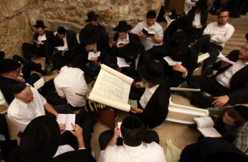 Jews sit on floor mourning loss of Temples on Tisha Be av