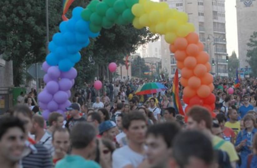 Parade marches beneath arch of rainbow balloons