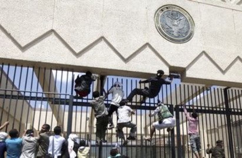 Protesters climb a fence at the US embassy in Sanaa 390 (R)