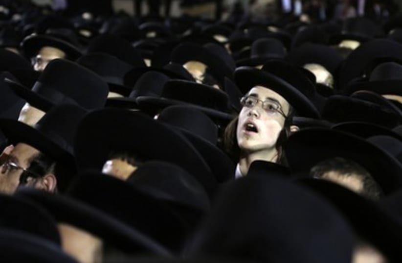 Haredi boy peers out of crowd 370