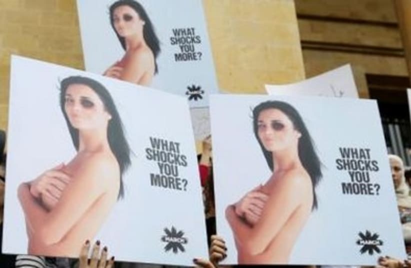  Women carry placards during a sit-in in Beirut against domestic violence against women, marking International Women's Day March 8, 2014.