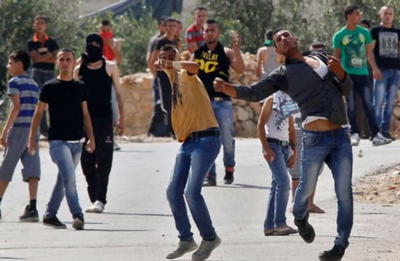 Palestinians hurl stones at Israeli troops near the West Bank City of Hebron June 13, 2014