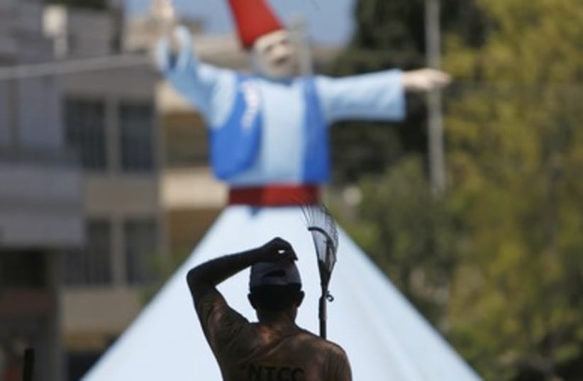 A worker walks past a whirling dervish statue erected as part of decorations ahead of the holy fasting month of Ramadan in the port city of Sidon, southern Lebanon.