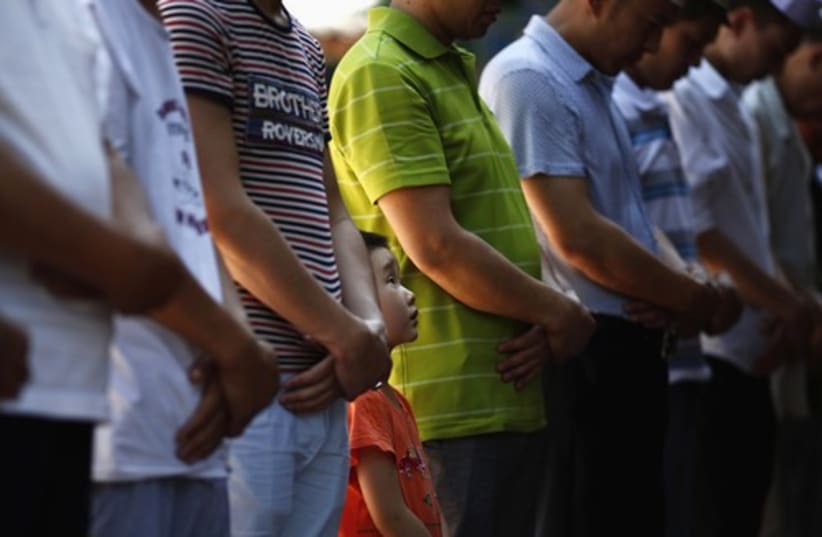 A boy attends a Friday prayer outside a worship hall of the Niujie Mosque in Beijing, June 27, 2014, ahead of the holy fasting month of Ramadan.