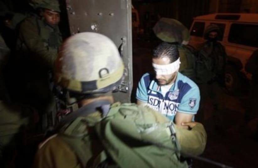 IDF soldiers detain a blindfolded Palestinians in Hebron.