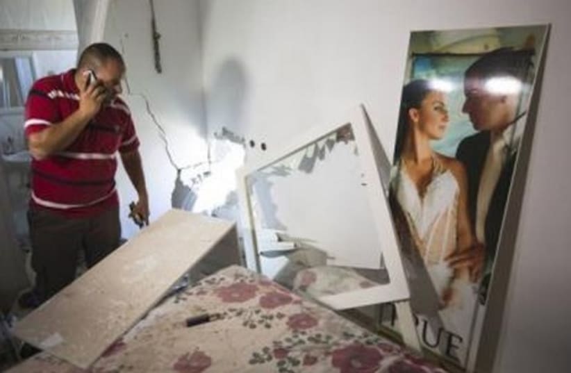 Avihai Jorno inspects the damage to his home after a rocket fired from Gaza hit his home in Sderot July 3, 2014.