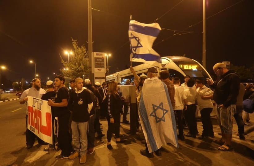  Israeli protesters gather at the site where a Palestinian terrorists rammed his car into a group of people at a Jerusalem Light Rail station, killing an infant girl.