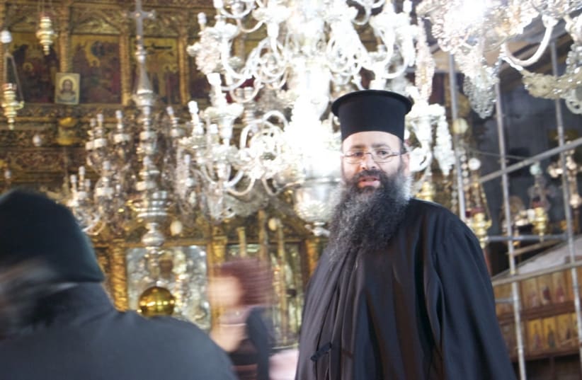 A Greek Orthodox priest watches pilgrims roam around the ancient church of nativity, where many Christians believe Jesus was born.