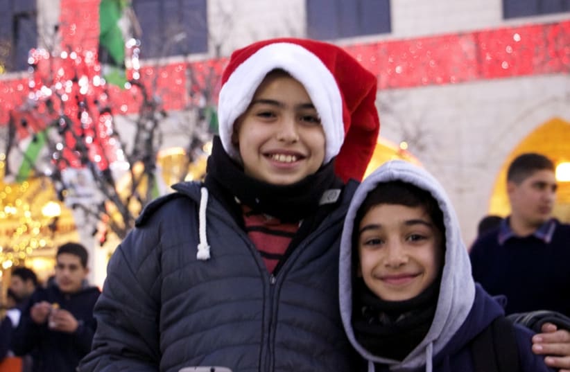 Two boys who were selling sweets to pilgrims pose for a picture in Manger Square, Bethlehem.