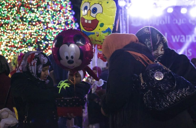 Balloons with popular cartoon figures such as Spongebob and Mickey mouse could be seen floating above the thick crowd in Manger Square, Bethlehem on Christmas Eve.