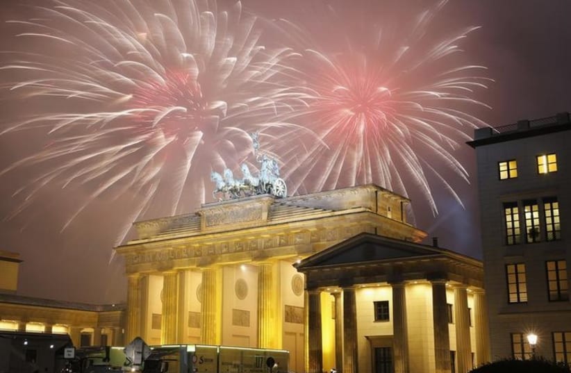 Fireworks explode next to the Quadriga sculpture atop the Brandenburg Gate during New Year celebrations in Berlin