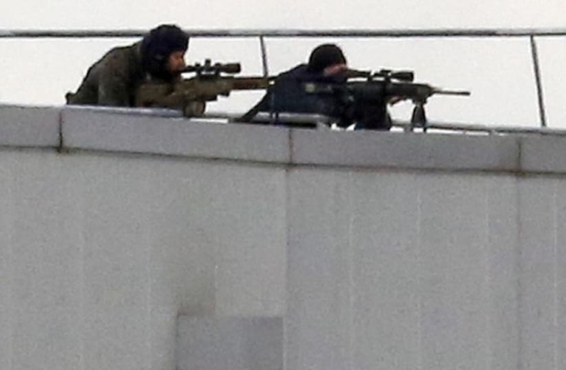 French special forces sharp shooters take position on a rooftop of the complex at the scene of a hostage taking at an industrial zone in Dammartin-en-Goele