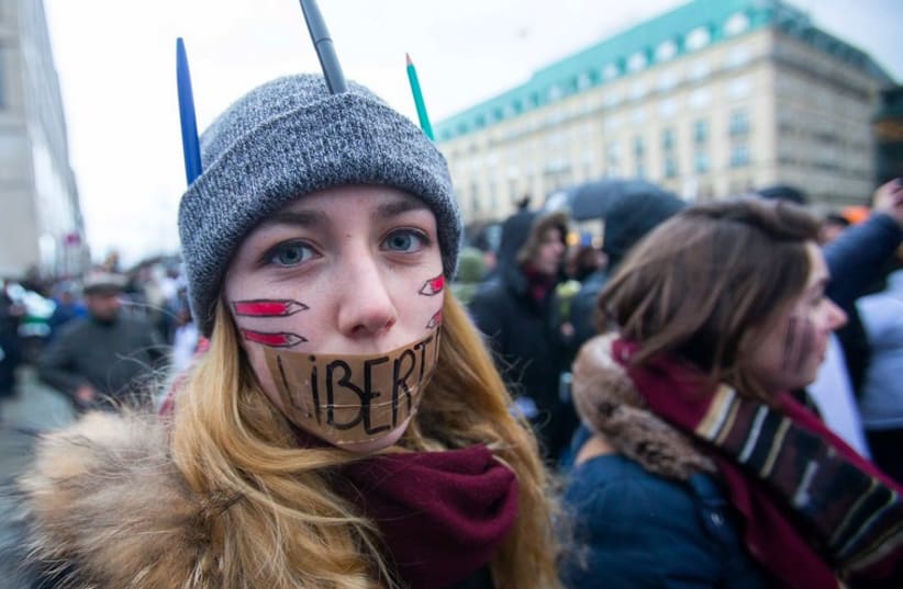 A woman wears a tape with the word 'Liberte' (Freedom) on her mouth during Paris solidarity march