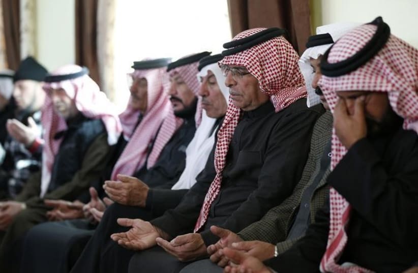 Saif al-Kasaesbeh (3rd R), father of Jordanian pilot Muath al-Kasaesbeh, prays at the family's clan headquarters with other mourners in the city of Karak