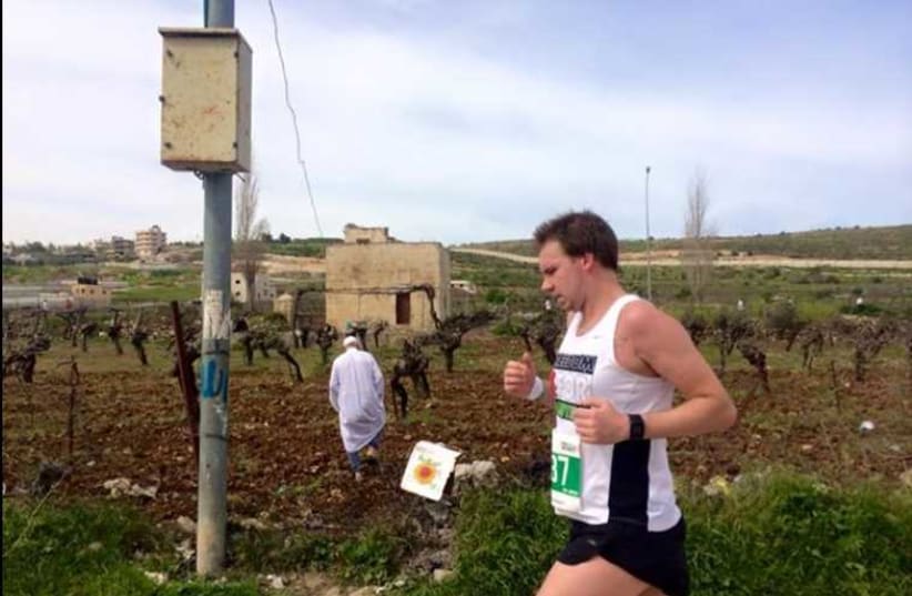 An international runners on the 21km route runs past a field in Bethlehem
