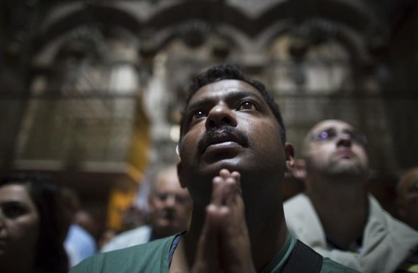 Christian worshipper take part in a prayer after a procession in the Church of the Holy Sepulchre on Good Friday, during Holy Week in Jerusalem's Old City