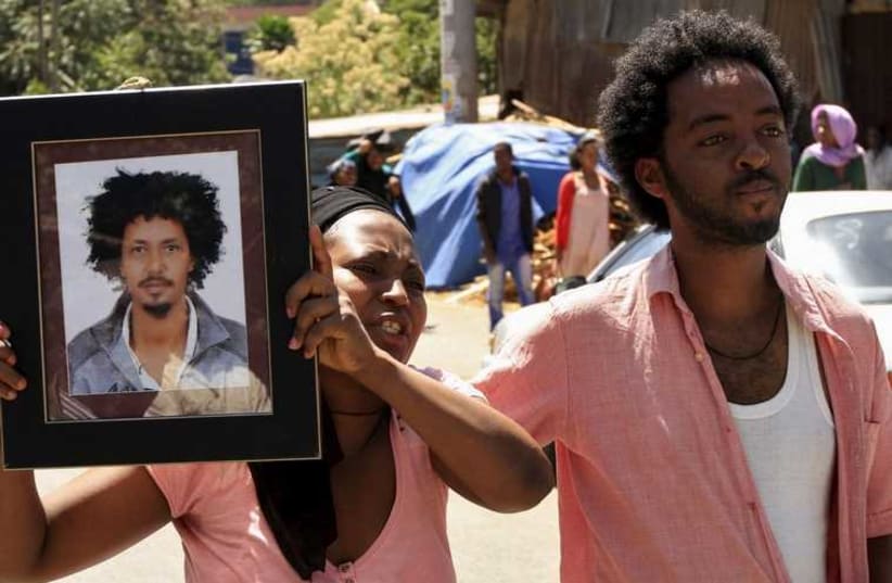 A woman mourns with the framed picture of a man said to be among the 30 Ethiopian victims killed by members of the militant Islamic State in Libya, in the capital Addis Ababa