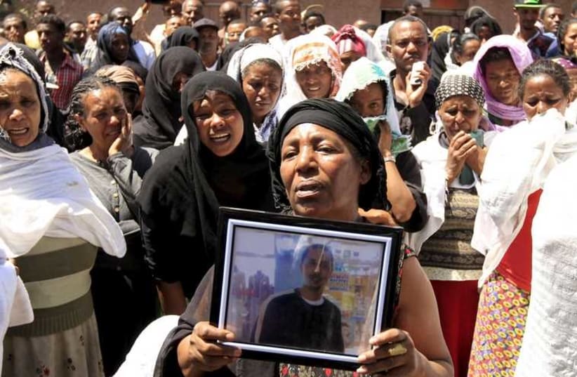 A woman mourns with the framed picture of a man said to be among the 30 Ethiopian victims killed by members of the militant Islamic State in Libya, in the capital Addis Ababa,