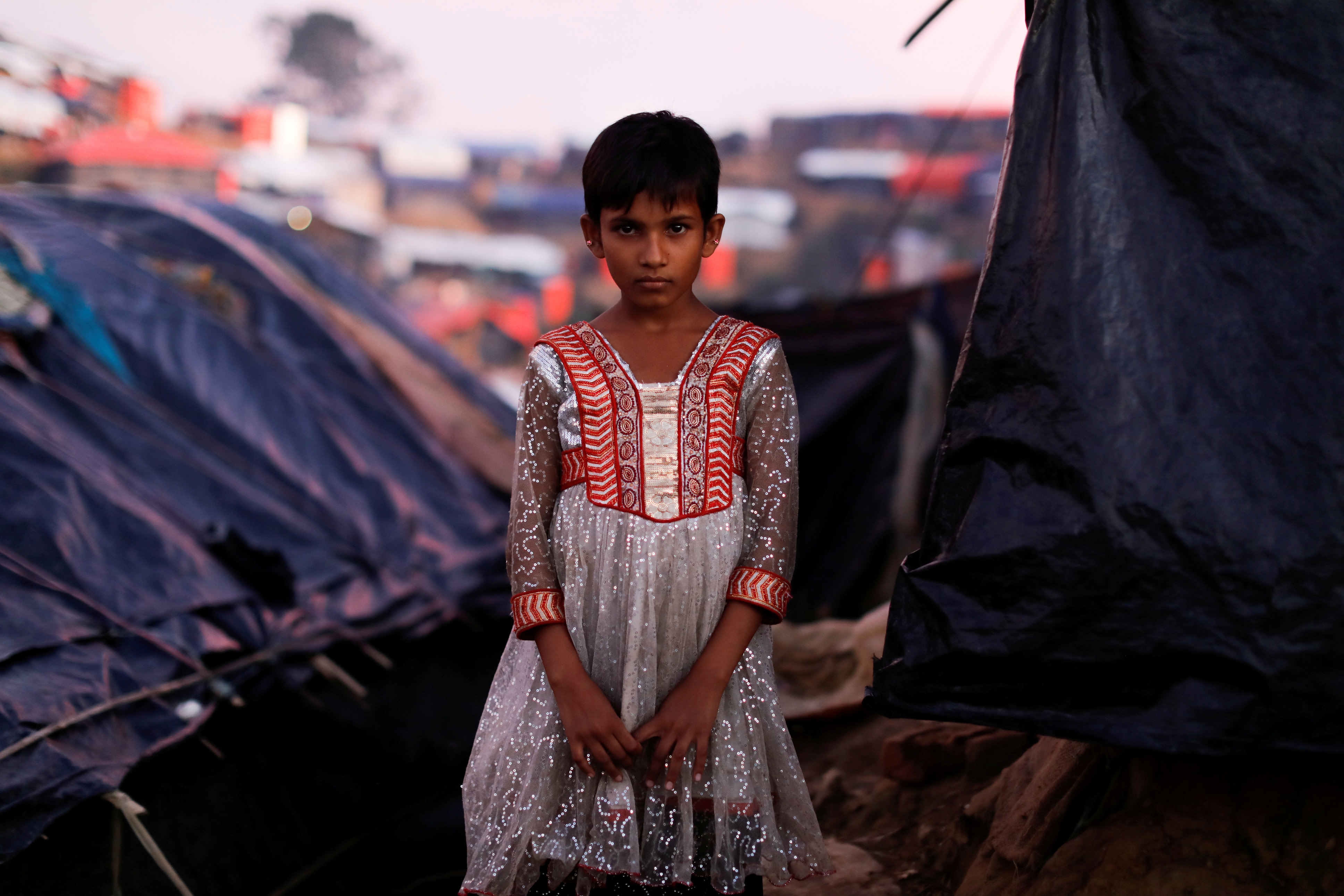 Mujan Begum, a 8-year-old Rohingya refugee, who arrived one month ago with her family poses outside her makeshift tent at a refugee camp near Cox's Bazar, Bangladesh October 11, 2017. (Reuters)